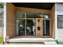 Close-up of a modern home's entrance with sleek black door, wood accents, and an array of expansive windows at 632 N Temple Ave, Indianapolis, IN 46201