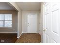 Inviting entryway with neutral paint, wood-look floors, and a bright front door at 6513 Kingsbury Way, Zionsville, IN 46077