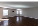 Spacious living room with hardwood floors and three large windows providing ample natural light at 6513 Kingsbury Way, Zionsville, IN 46077