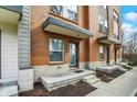 View of the townhome entrances, each featuring a covered porch and updated landscaping that welcomes visitors at 805 Switchyard Pl, Indianapolis, IN 46202
