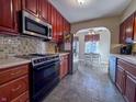 Well-equipped kitchen featuring stainless steel appliances, dark wood cabinets and tile backsplash at 850 N Butler Ave, Indianapolis, IN 46219