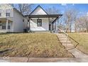 Adorable house with a covered front porch, featuring a welcoming entrance and freshly painted black trim at 866 W 29Th St, Indianapolis, IN 46208