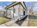 Close-up highlighting a covered front porch with black trim, fresh landscaping, and a welcoming entrance at 866 W 29Th St, Indianapolis, IN 46208