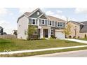 Beautiful two-story home with a well-manicured lawn, a two-car garage, and a classic gray and brick facade at 1040 Arthur Ct, Greenfield, IN 46140