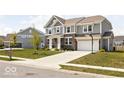 Attractive two-story home with gray siding, brick accents, a two-car garage, and a driveway with a basketball hoop at 1040 Arthur Ct, Greenfield, IN 46140