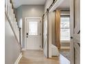 Elegant foyer with hardwood floors, stairs, and view of a lovely barn door and window at 1041 S State Ave, Indianapolis, IN 46203