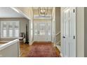 Bright foyer with a decorative front door, chandelier, hardwood floor, and staircase at 113 Edgewater Dr, Noblesville, IN 46062