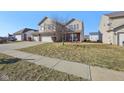 Well-maintained two-story home with three-car garage, green lawn and sidewalk at 11624 Eldridge Dr, Indianapolis, IN 46235