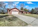 Low angle view of a brick home with an attached garage and long driveway at 12 Danridge Dr, Danville, IN 46122