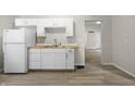 Kitchen featuring white cabinets, laminate countertops and vinyl floors at 1211 W 30Th St, Indianapolis, IN 46208