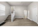 Open concept living room with staircase, vinyl flooring, and neutral paint at 1211 W 30Th St, Indianapolis, IN 46208