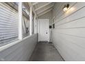 Covered front porch featuring a white door, gray wood and an outdoor light at 1211 W 30Th St, Indianapolis, IN 46208
