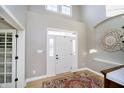 Bright foyer with high ceilings, a decorative rug, white trim, and a front door with sidelights at 12433 Harvest Glen Blvd, Fishers, IN 46037