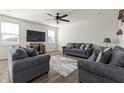 Comfortable living room with cozy seating, wood floors, ceiling fan and natural light from multiple windows at 1399 Hat Band St, Danville, IN 46122
