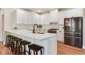 Modern kitchen with white cabinets, stainless steel appliances, island with quartz countertop, and seating at 14870 Starboard Rd, Fishers, IN 46040