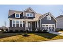 Beautiful two-story home with gray siding, brick accents, and manicured front yard at 14879 Thornapple Dr, Carmel, IN 46032