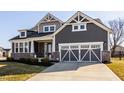 Charming two-story home with gray siding, brick accents, and a two-car garage at 14879 Thornapple Dr, Carmel, IN 46032