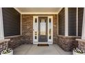 Inviting front porch with brick columns and a stylish glass-paneled front door at 14879 Thornapple Dr, Carmel, IN 46032