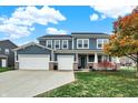 Beautiful two-story home with a large front lawn, three-car garage, and inviting front porch at 15831 Eastpark Dr, Noblesville, IN 46060
