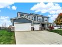 Charming home featuring a spacious driveway leading to a three-car garage, set against a lush green lawn at 15831 Eastpark Dr, Noblesville, IN 46060