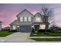 Attractive two-story home featuring well-lit exterior, manicured lawn, and a two-car garage at 16753 Workington Way, Westfield, IN 46074