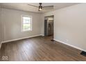 Bright, open living area with wood floors, neutral walls, ceiling fan, and stainless steel refrigerator in view at 1707 N Leland Ave, Indianapolis, IN 46218