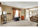 Bright living room featuring carpet, large windows, and a staircase to the second floor at 2255 Colfax Ln, Indianapolis, IN 46260