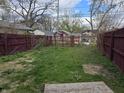 View of the backyard, featuring a weathered, maroon-painted fence at 335 S Dearborn St, Indianapolis, IN 46201
