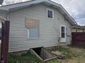 Back exterior of home with walkout basement access and boarded up window at 335 S Dearborn St, Indianapolis, IN 46201