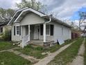 Exterior view of the home featuring a small porch and a gravel driveway at 335 S Dearborn St, Indianapolis, IN 46201
