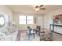 Bright living room with a large window, comfortable seating, and a stylish ceiling fan at 3813 N Hartman Dr, Indianapolis, IN 46226