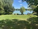 Expansive backyard with mature trees and view of the lake, perfect for outdoor activities at 5515 Shorewood Dr, Indianapolis, IN 46220