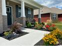 Landscaped front porch with rocking chair and colorful flowers at 603 Blarney Dr, Pendleton, IN 46064