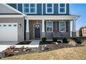 Inviting covered front porch with a wooden bench, tasteful landscaping, and a welcoming wreath on the front door at 603 Blarney Dr, Pendleton, IN 46064