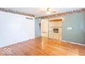 An expansive living room showcasing beautiful hardwood floors and open access to the brick fireplace room at 613 Barrett St, Danville, IN 46122
