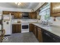 Functional kitchen with wood cabinetry, white countertops, and essential appliances at 6204 S Madison Ave, Indianapolis, IN 46227