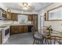 Traditional kitchen features wood cabinets, white appliances, and an adjacent dining area at 6204 S Madison Ave, Indianapolis, IN 46227