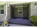 Covered porch featuring decorative ironwork, neutral stone walls, and an outdoor statue at 6204 S Madison Ave, Indianapolis, IN 46227