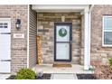 Close up of the front door with welcome sign, wreath, house number, and stone wall at 6615 Aberdeen Dr, McCordsville, IN 46055