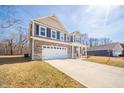 Two-story home featuring a spacious driveway leading to a two-car garage and inviting front porch at 6699 Dunkirk Dr, McCordsville, IN 46055