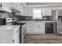 Modern kitchen featuring white cabinets, stainless steel appliances, and luxury vinyl plank flooring at 7089 W Us Highway 36, Danville, IN 46122