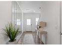 Bright entryway featuring a modern mirror, light wood flooring, and a view of the front door at 737 Oxford Ln, Danville, IN 46122