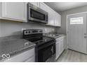 Modern kitchen featuring stainless steel appliances, white cabinets, and gray walls at 741 Southfield Ct, Indianapolis, IN 46227