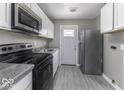 Modern kitchen featuring stainless steel appliances, white cabinets, and gray walls at 741 Southfield Ct, Indianapolis, IN 46227
