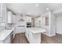 Spacious kitchen featuring stainless steel appliances, an island, white cabinets, and modern lighting at 8445 Morgan Ln, Zionsville, IN 46077