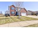 Two-story home with brick facade, attached garage, and a well-maintained front lawn at 983 Geronimo Dr, Greenfield, IN 46140
