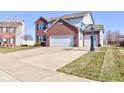 Two-story brick home with two-car garage, basketball hoop, and well-kept lawn at 983 Geronimo Dr, Greenfield, IN 46140
