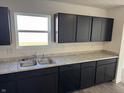A well-lit kitchen features black cabinets, stainless steel sink, and new appliances at 1195 Andromeda Dr, Franklin, IN 46131