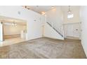 Open concept living room with high ceilings, a staircase, and seamless transition to kitchen at 12683 Raiders Blvd, Fishers, IN 46037