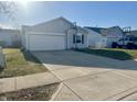 Charming single-Gathering home showcasing a driveway, garage, and gray siding at 13250 N Brick Chapel Dr, Camby, IN 46113